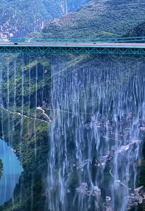 花江峡谷大桥水帘 和住户形成若影若现的美景